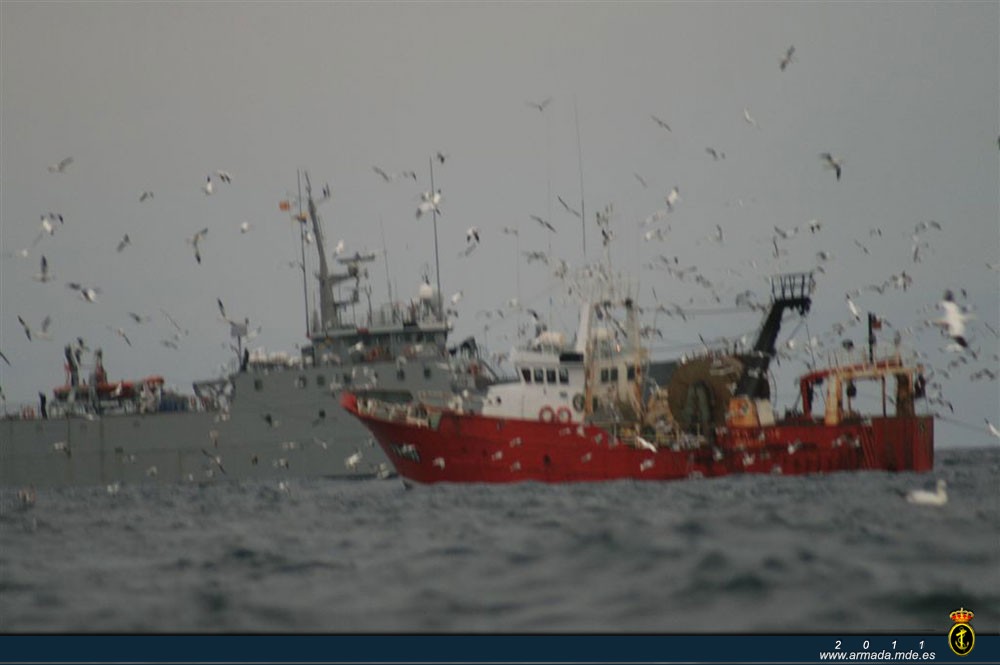 De fondo, el patrullero de la Armada 'Chilreu' en una de sus misiones de vigilancia y apoyo a los pesqueros